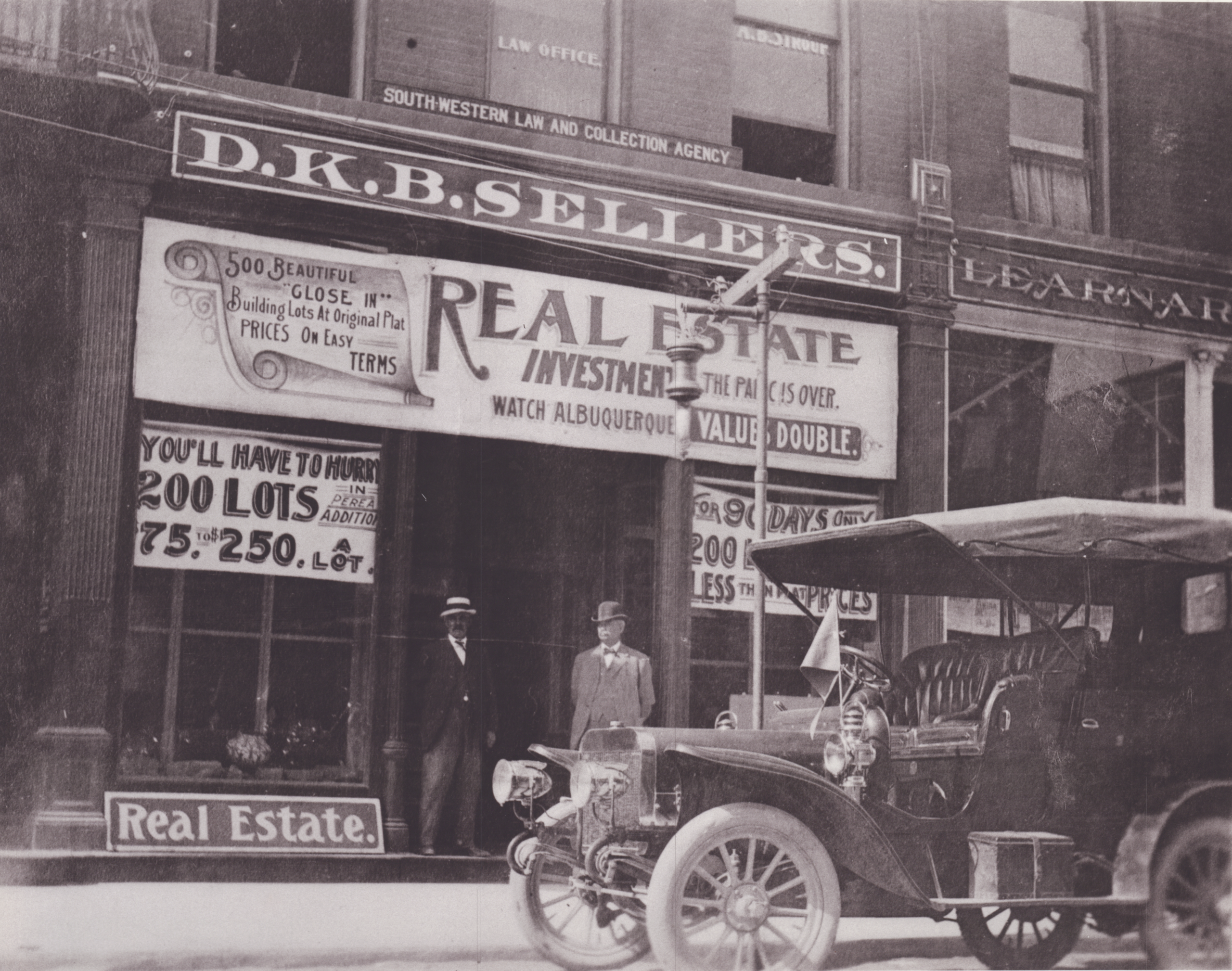 Image of D.K.B. Sellers in front of his real estate office with car around 1925 in downton Albuquerque