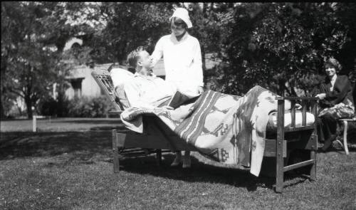 A nurse tending to a TB patient outdoors.